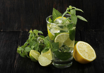 mojito with lemon, mint and ice isolated on wooden background