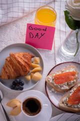 Continental breakfast captured from above (top view, flat lay). Coffee, orange juice, croissant, sandwich and flowers. sticker note wishing