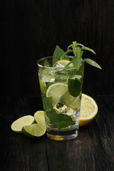 mojito with lemon, mint and ice isolated on wooden background