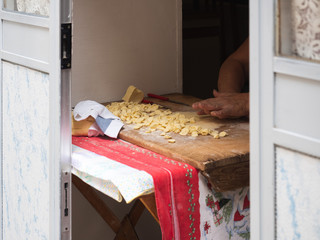 Homemade traditional pasta (orecchiette) on a wooden board. Bari, Italy. Tasty food concept