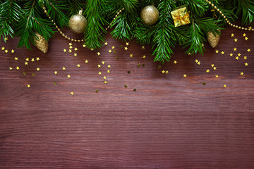 Christmas decorations and fir tree branches on wooden plank.