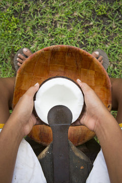 Terevau, 11 years old, grates a coconut to extract copra first, then coconut milk, motu Tiapaa, Maupiti Island, Leeward Islands, French Polynesia