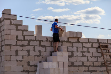 Worker lays bricks at a house construction