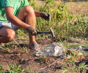 A man breaks stones with a hammer