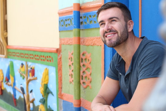 Man smiling close to building with colourful zocalos