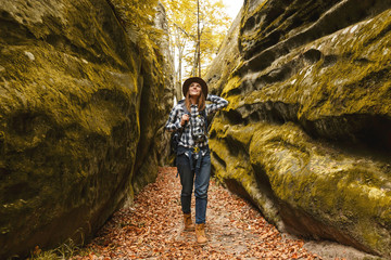 Travel young woman wearing brown hat, plaid shirt, jeans and brown boots with backpack ready to...