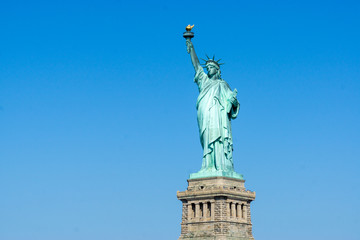 Fototapeta na wymiar The Statue of Liberty in New York City isolated on on a blue sky background