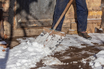 Man cleans the road from snow in winter