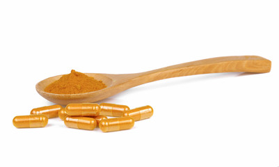Turmeric powder and turmeric capsules on white background