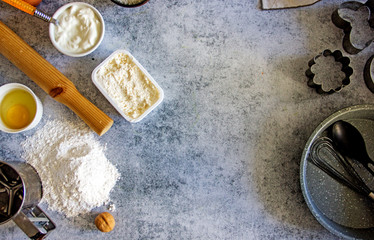 Ingredients for baking - raw egg, flour, brown sugar, nuts, soft cheese on a stone background