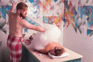 Special equipment. Red haired bearded man holding a special stick while doing professional foam...