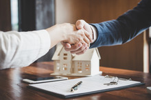 Real estate agent and customers shaking hands together celebrating finished contract after about home insurance and investment loan, handshake and successful deal