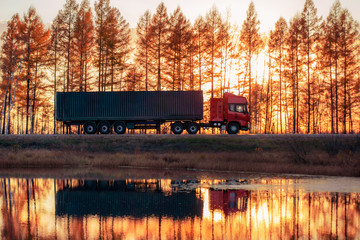 Red truck on a road at sunset
