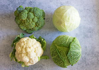 Four types of cabbage on a dark background: white, Savoy, cauliflower, broccoli