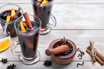 Mulled wine with cinnamon, orange fruit and anise stars on wooden background, copy space.