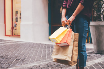 Consumerism, shopping lifestyle concept, Young woman standing and holding colorful shopping bags enjoying in shopping