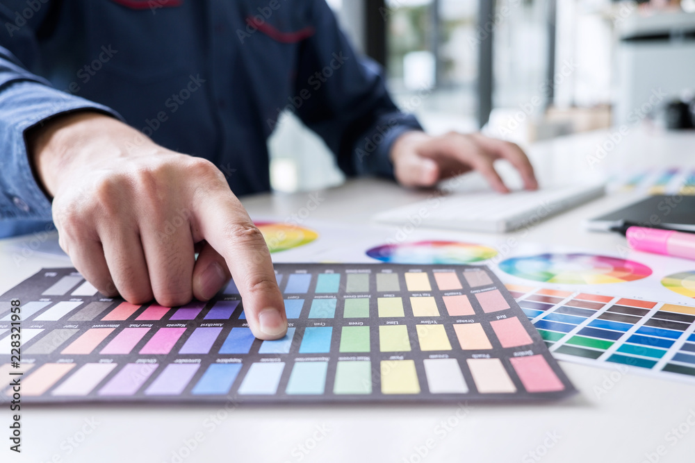 Aufkleber male creative graphic designer working on color selection and color swatches, drawing on graphics ta