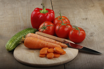 carrots, cucumbers,red pepper and tomatoes on wooden background