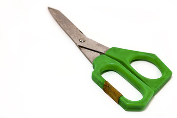Green plastic handle scissors on white floor