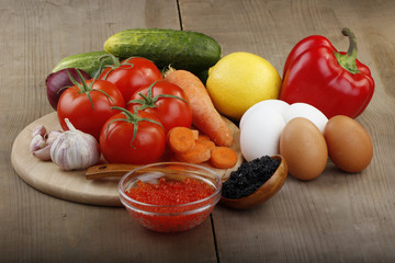 vegetables and eggs and caviar on wooden background