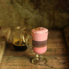 beetroot latte (beet juice) - coffee with milk in a transparent cup on the table. top view.
