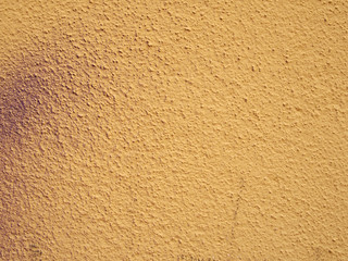 a pale grainy textured yellow wall background with hints of messy purple spray paint