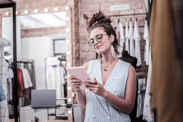 Reading e-mail. Successful appealing businesswoman holding tablet reading working e-mail standing...