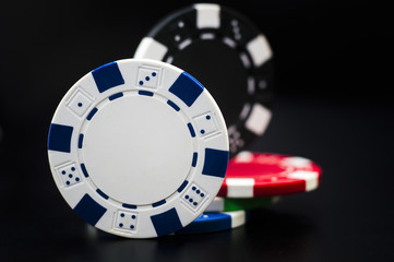 set of poker chips of different colors on a black background.