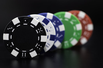 set of poker chips of different colors on a black background.