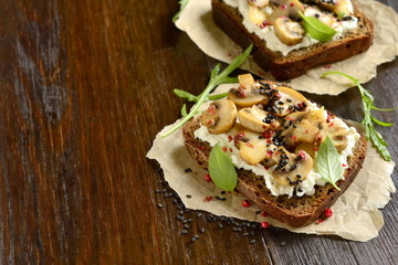 Sandwich with fried mushrooms, cream cheese, pink pepper and black sesame, copy space