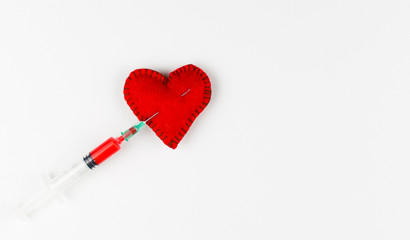 An injection of love in the heart. Stitched heart and syringe with red liquid on a white background.