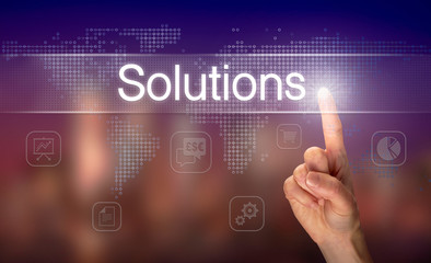 Obraz premium A hand selecting a Solutions business concept on a clear screen with a colorful blurred background.