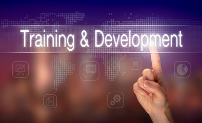 A hand selecting a Training and Development business concept on a clear screen with a colorful blurred background.