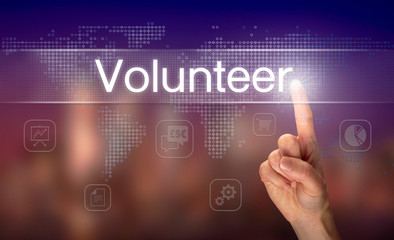 A hand selecting a Volunteer business concept on a clear screen with a colorful blurred background.