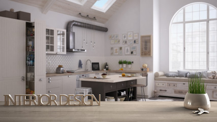 Wooden table, desk or shelf with potted grass plant, house keys and 3D letters making the words interior design, over blurred contemporary kitchen, project concept copy space background