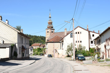 Fototapeta premium dorpsstraat met kerktoren en bovengrondse stroomleidingen in Provenchères-sur-Fave in de Vogezen