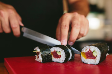 Man cutting fresh sushi - obrazy, fototapety, plakaty