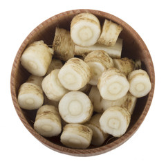 roots of fennel in wooden cup isolated. top view