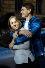 Obraz premium Portrait of a happy couple hugging in the street, in the city.standing in better from the sun, hard light. date