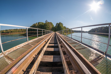 Fototapeta na wymiar iron steel frame construction of narrow gauge railway bridge across the river. Wide angle view