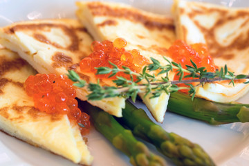 Sliced omelette with red caviar close up