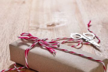 craft box tied with red and white rope on wooden table