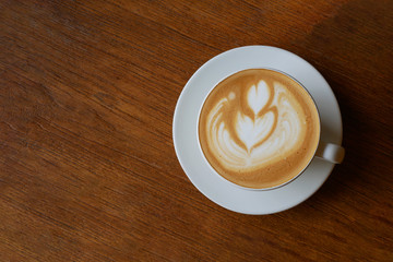 Hot coffee cappuccino latte art top view on dark wooden background
