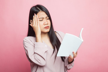 Young Asian woman got headache read a book.