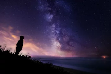 Fototapete Nacht Silhouette eines einsamen Mannes, der die Sterne und die Milchstraße über dem Meer in der Toskana beobachtet