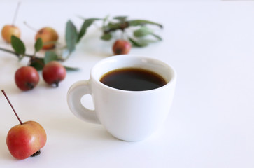 Cup of coffee with little apples on white wooden background . Flat lay, top view.Empty space for your text.