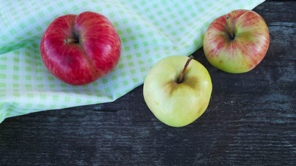 Fresh sweet apples on light napkin on wooden background.