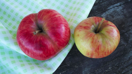 Fresh sweet apples on light napkin on wooden background.