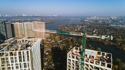 Obraz premium Aerial view of landscape in the city with under construction buildings and industrial cranes. Construction site.