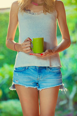 Girl drinking coffee / tea in the garden.